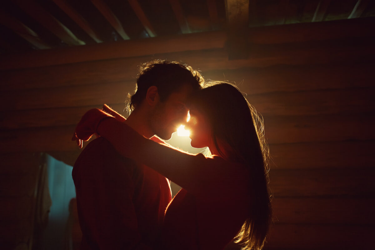 Young couple in love. Kissing man and woman at home in intimate atmosphere